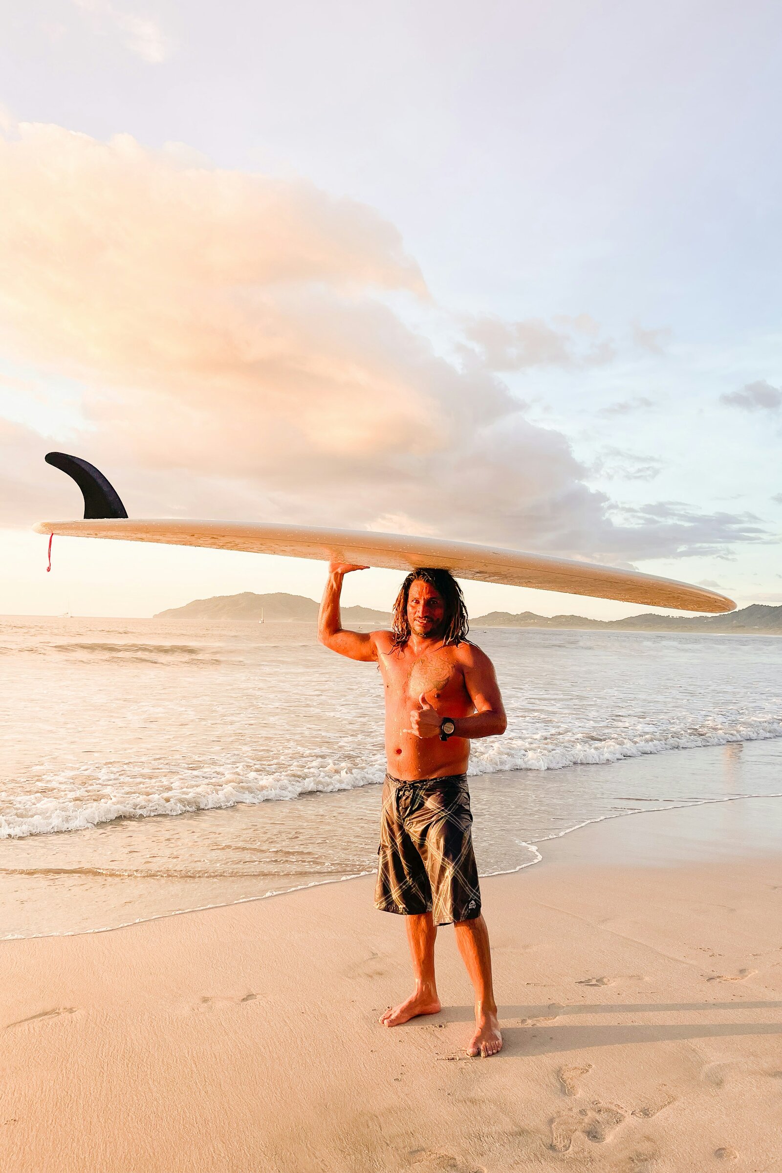 Local surfer at sunset on Tamarindo beach, Guanacaste, Costa Rica